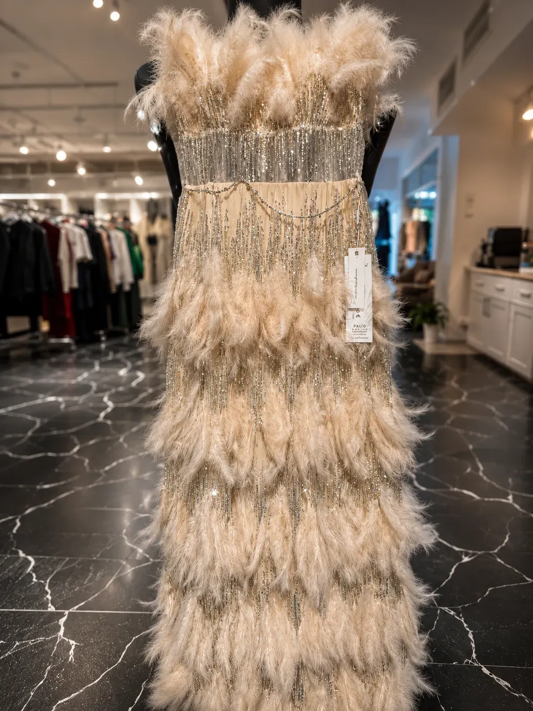 Bodenlanges Abendkleid in Champagner mit Federbesatz und Perlenfransen auf der Verkaufsfläche.